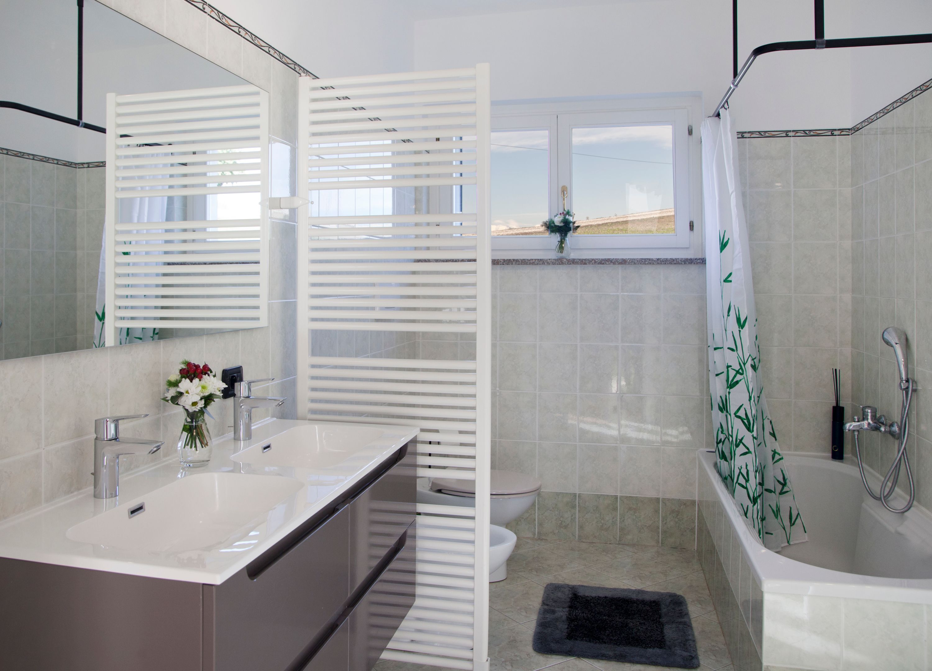 Un baño moderno con un lavamanos grande, espejo y ducha.