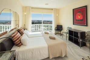 A hotel room with a large bed, a desk, a chair, a TV, and a balcony with a view. - Large Luxury Family Villa 500m From Beach (Mijas)