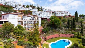 A hillside residential area with white houses, a swimming pool, and lush greenery. - Apartamento Ladera Solset (Nerja)