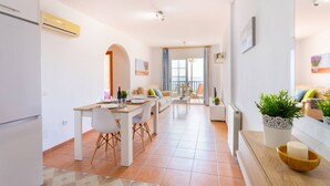 A modern apartment with a dining area, kitchen, and living space. - Apartamento Ladera Solset (Nerja)