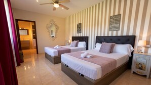Habitación de hotel con dos camas, ventilador de techo, espejo y una pared con citas inspiradoras.