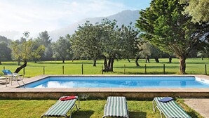 Ein Swimmingpool mit drei Liegestühlen und einem roten Handtuch.