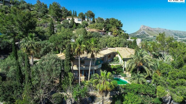 A villa surrounded by lush greenery and a mountain backdrop. - El Vilar 60 Villa Puerto Pollenca (Pollença)