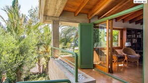A modern outdoor balcony with a concrete floor, green railing, and a view of lush greenery. - El Vilar 60 Villa Puerto Pollenca (Pollença)
