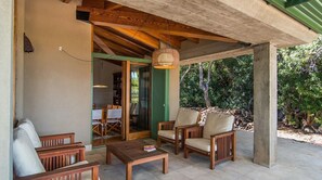 A covered outdoor seating area with wooden furniture and a hanging lamp. - El Vilar 60 Villa Puerto Pollenca (Pollença)