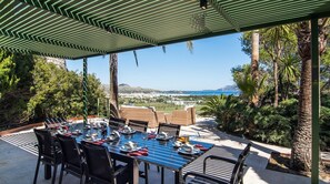 An outdoor dining area with a view of the sea and hills. - El Vilar 60 Villa Puerto Pollenca (Pollença)