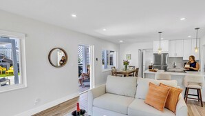 Ein modernes Wohnzimmer mit Sofa, Essbereich und Küche.