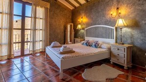 Une chambre à coucher avec un lit, des lampes de chevet, une table de chevet, un miroir et une vue par la fenêtre.