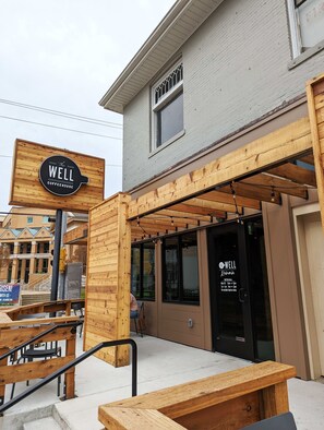 A wooden exterior with a sign reading "The Well Coffeehouse." - The Vinyl at Music Row - 1 Bedroom Apartment (Nashville)