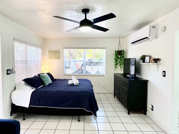 A bedroom with a bed, a ceiling fan, a window, a dresser, and a television. - Southwinds 5 for 5 Guests -near the Beach (Hollywood)