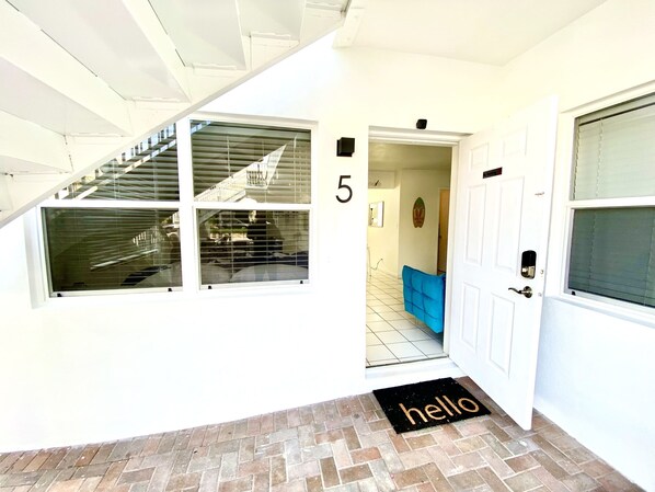 A hallway with a staircase, a blue couch, and a door marked with the number 5. - Southwinds 5 for 5 Guests -near the Beach (Hollywood)