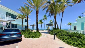A beachfront hotel with palm trees, a car parked in front, and a clear view of the ocean. - Beach Lover s Studio Apartment in Hollywood FL (Hollywood)