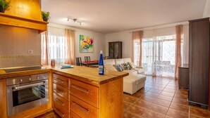 A modern kitchen with wooden cabinetry, a built-in oven, and a central island. - Villa Rosa in Callao Salvaje (Adeje)