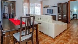 A living room with a dining table, a sofa, and a TV. - Villa Rosa in Callao Salvaje (Adeje)