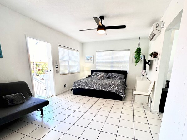 A bedroom with a bed, a desk, a chair, a ceiling fan, and a window. - Southwinds 6 for 3 Just Steps From the Beach (Hollywood)