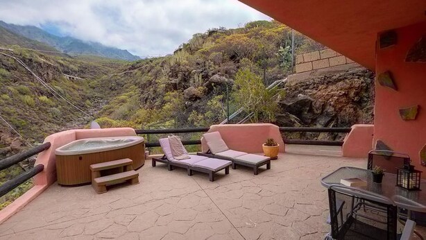 A patio with lounge chairs, a hot tub, and a table with a potted plant. - Apartamento Vulcano in Adeje (Adeje)