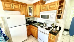 A kitchen with wooden cabinets, a white refrigerator, a stove, a microwave, and a sink. - Southwinds 8 for 2 Steps to Beach Boardwalk (Hollywood)