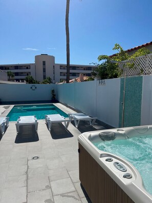 A swimming pool area with lounge chairs and a hot tub. - Villa Magnolia in Callao Salvaje (Adeje)