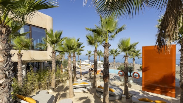A resort with palm trees, sun loungers, and a pool area. - Sunset Top Floor Apartment Higueron (Fuengirola)