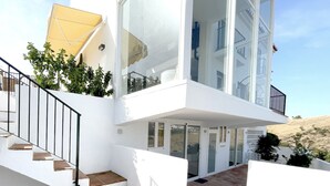 A modern two-story house with a white exterior, a staircase with wooden steps, and a tiled patio area. - Casa Kodak - Las Lagunas de Mijas (Mijas)