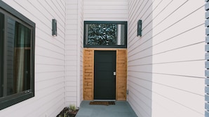 A modern house with a wooden door and a window above it. - Misha: 6443 Redpine Road, Dallas (Dallas)
