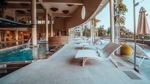 A pool area with lounge chairs, a water feature, and large windows. - Luxury Apartment With Terrace in Higueron (Fuengirola)