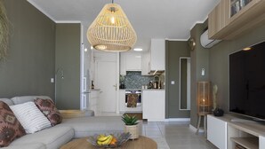 A modern living room with a sofa, coffee table, and TV. - Central Apartment With Seaview Terrace and Pool (Benalmádena)