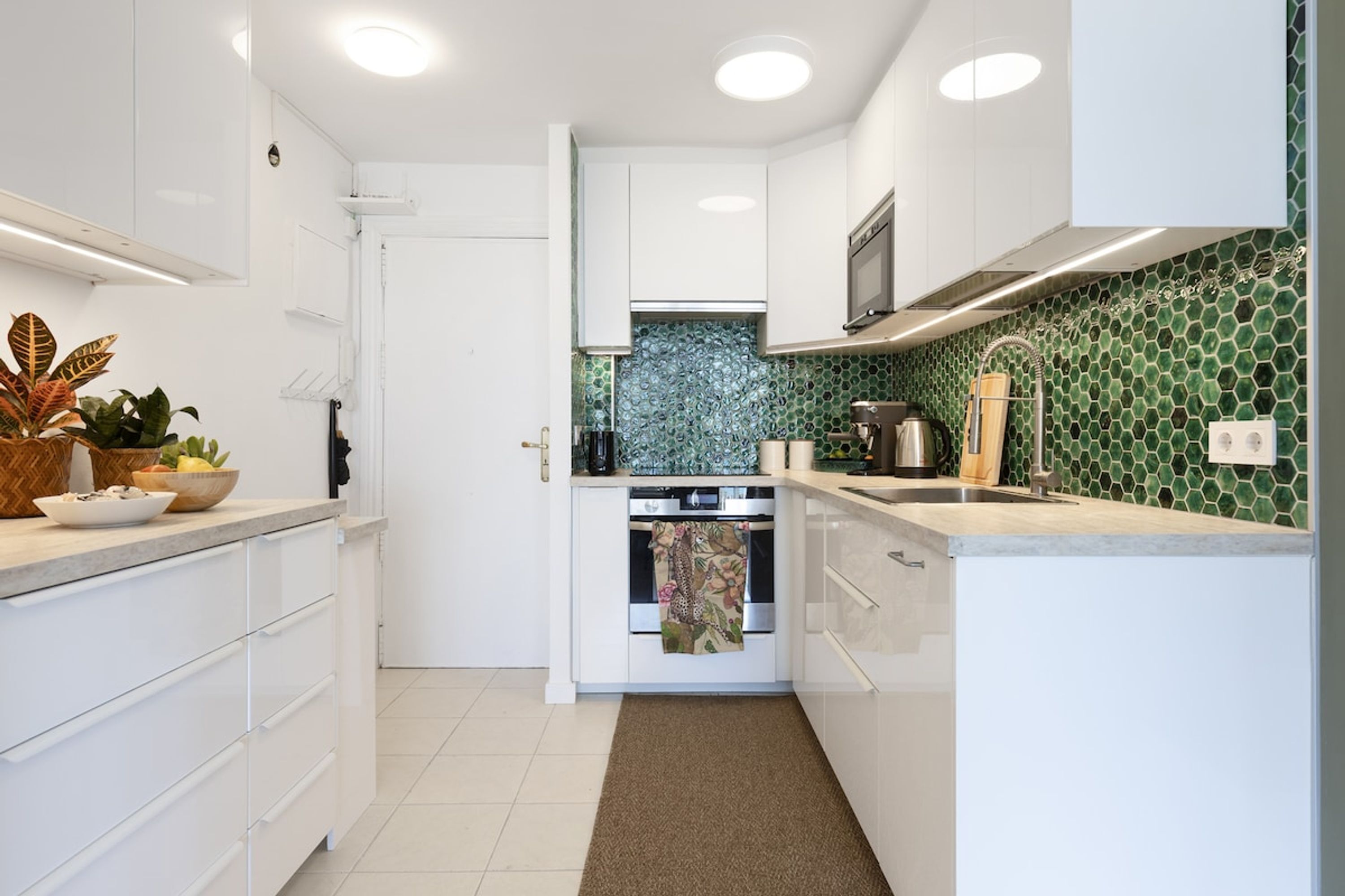 A compact kitchen with white cabinets, a microwave, and a stove.