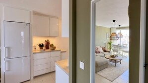 A modern kitchen with white cabinets and a built-in LG refrigerator. - Central Apartment With Seaview Terrace and Pool (Benalmádena)