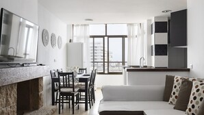 Een moderne woonkamer met een open haard, eethoek en keuken.