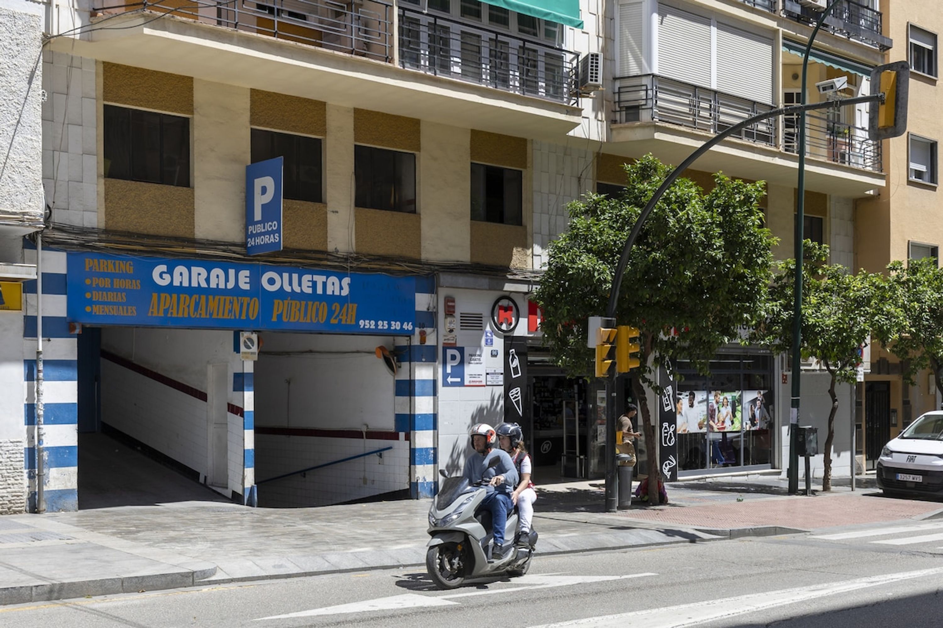 Un edificio con un letrero azul y blanco para un estacionamiento público.
