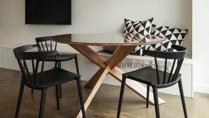 A modern dining area with a glass table, black chairs, and a woven pendant light. - Aquabelle Three on Rye Beach (Melbourne)