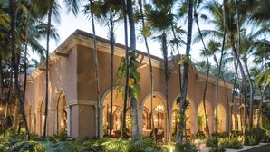 A resort with a central building featuring arched walkways and a well-maintained lawn.
