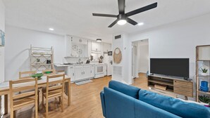 A modern living space with a dining area, kitchen, and a large flat-screen TV. - Flint B (Waco)