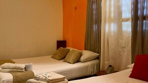 Une chambre d’hôtel avec deux lits, une petite table et une table de chevet.