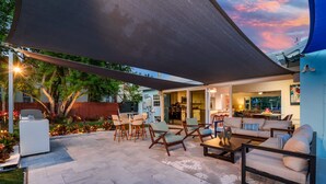 Une terrasse extérieure avec des sièges, un barbecue et une vue sur le jardin.