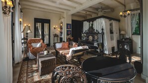 A spacious room with a large dining table, multiple chairs, and a sofa. The room features exposed wooden beams, a chandelier, and a large mirror. - Hacienda Palancar Sian Ka an Luxe 11br (Tulum)