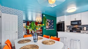 A modern kitchen with white cabinets, a microwave, and a refrigerator. - Eccentric Home With Pool Tiki hut Outdoor Kitchen (Pompano Beach)