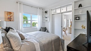 A bedroom with a large bed, a TV, and a view of the outdoors. - Walk to Ft Lauderdale Beach - Water Views Pool (Fort Lauderdale)