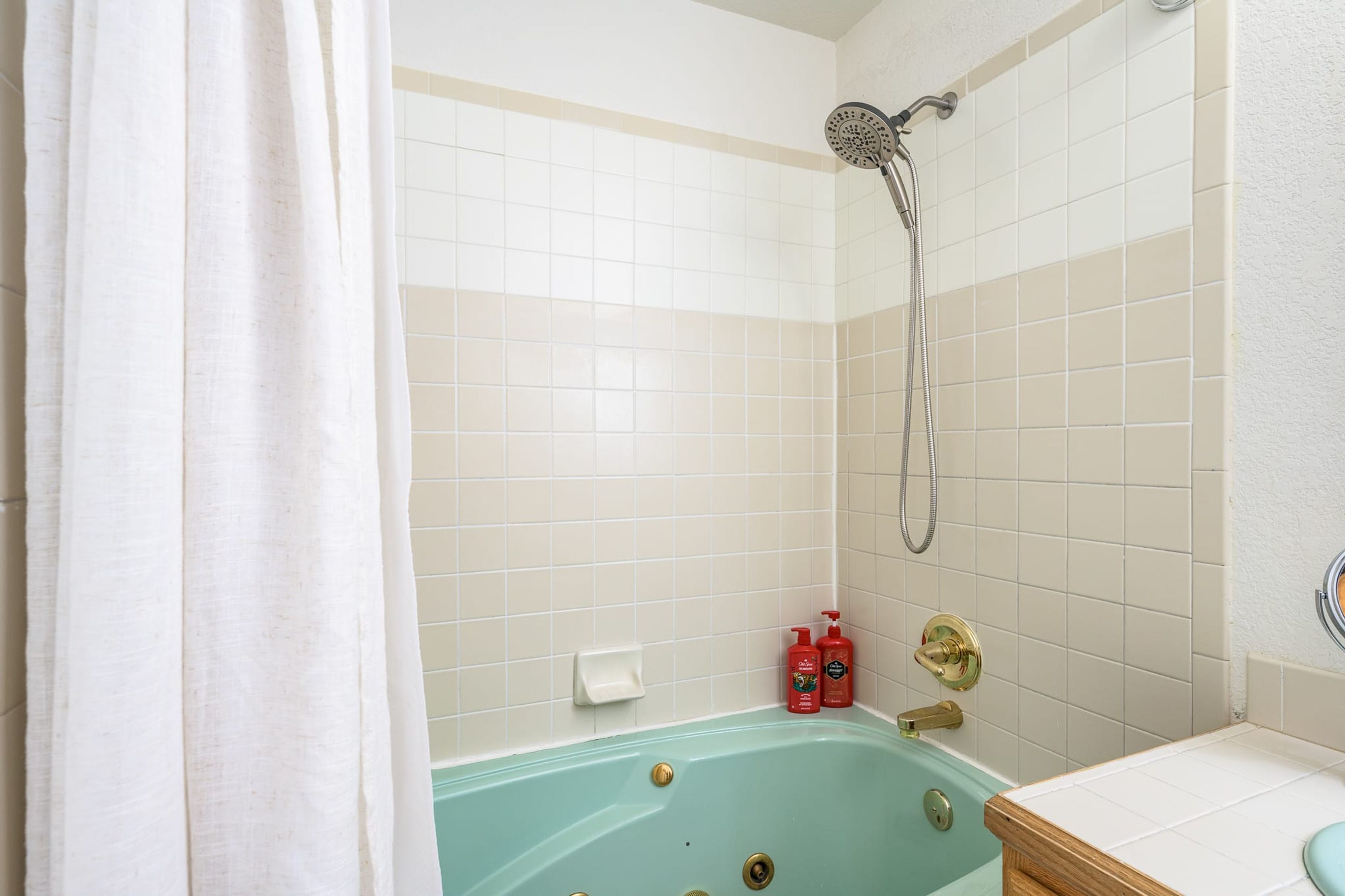 A bathroom with a bathtub, shower, and toilet.