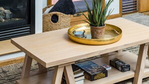 Una mesa de madera con una bandeja, una planta en maceta y libros.