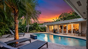 A swimming pool with lounge chairs, a palm tree, and a house with a patio. - Cypress Cove - HTD Pool Near Lauderdale By The Sea (Fort Lauderdale)