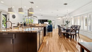 A spacious kitchen with a large island, wooden flooring, and pendant lighting. - Cypress Cove - HTD Pool Near Lauderdale By The Sea (Fort Lauderdale)