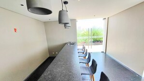 A conference room with a long table, several chairs, and pendant lights. - Luxurious High-rise HS Wifi Amazing City Views (Mexico City)