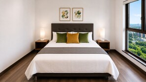 A modern hotel room with a large bed, two nightstands, a view of the city, and two framed artworks on the wall.