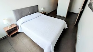 A hotel room with a bed, a nightstand, a lamp, and a door leading to another room. - Alluring Views Luxuriously Appointed in Polanco (Mexico City)