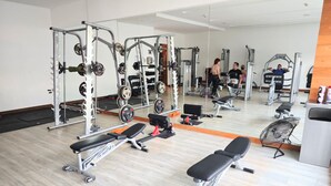 A gym with weightlifting equipment, benches, and a mirrored wall. - City View Oasis KS Bed Pool Hot Tub Gym (Mexico City)