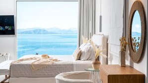 A bedroom with a large window overlooking a body of water and mountains. There is a bed with white bedding and a bedside table with a vase of dried flowers. - Achillion Luxury Corfu Villa (Corfu)