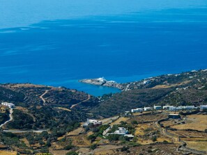 A coastal landscape with buildings, a road, and a body of water. - Sigma Residences Sifnos (Sifnos)