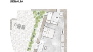 Vista cenital de la distribución de un hotel Seralia, con patio de piedra, mobiliario exterior y zona de cocina.